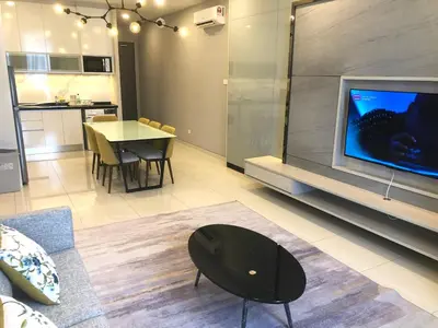 a living room with a large tv and a table at M and S Suite at Societe Suites Sri Hartamas, Mont Kiara in Kuala Lumpur