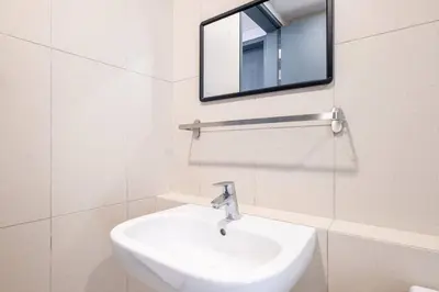a white bathroom with a sink and a mirror at Kids Wonderland opposite MyTown near TRX Mall MRT in Kuala Lumpur