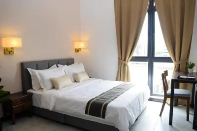 a bedroom with a bed with white sheets and a window at Neu Suites by Snugster 2 Bedroom, 3km to KLCC in Kuala Lumpur