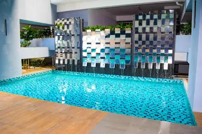 a swimming pool with blue water in a building at Neu Suites by Snugster 2 Bedroom, 3km to KLCC in Kuala Lumpur