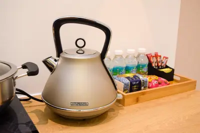 a tea kettle sitting on a counter with bottles of water at Neu Suites by Snugster 2 Bedroom, 3km to KLCC in Kuala Lumpur