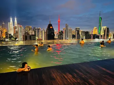 a group of people in a swimming pool with a city skyline at Spritz Empire Regalia Suites & Residence in Kuala Lumpur