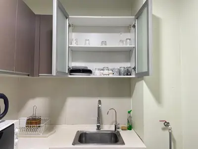 a kitchen counter with a sink and shelves at Spritz Empire Regalia Suites & Residence in Kuala Lumpur
