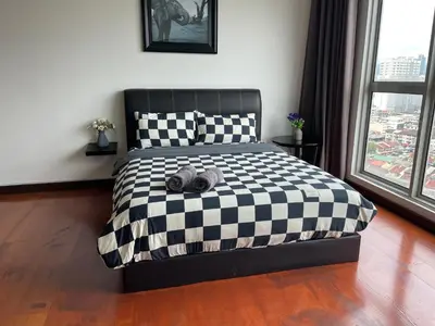a black and white bed with a teddy bear on it at Spritz Empire Regalia Suites & Residence in Kuala Lumpur