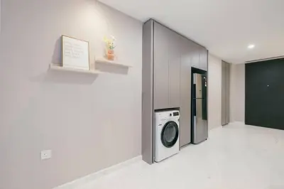 a laundry room with a washing machine in a wall at NEW! Eaton Infinity SKY POOL KLCC view Pavilion in Kuala Lumpur