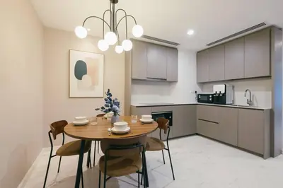 a kitchen and dining room with a wooden table and chairs at NEW! Eaton Infinity SKY POOL KLCC view Pavilion in Kuala Lumpur