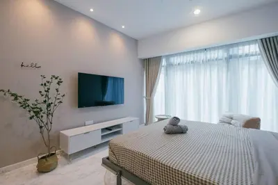 a bedroom with a bed with a tv on the wall at NEW! Eaton Infinity SKY POOL KLCC view Pavilion in Kuala Lumpur