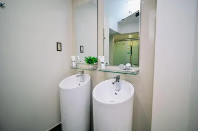a bathroom with two sinks and a mirror at Swing & Pillows - Central Market Kuala Lumpur in Kuala Lumpur