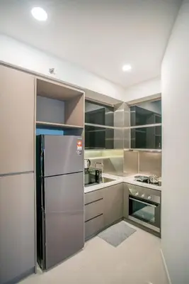 a kitchen with a stainless steel refrigerator at Novo Ampang by COBNB near Gleneagles in Kuala Lumpur