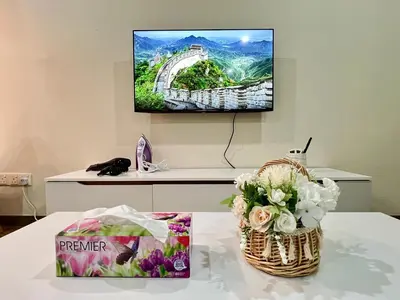 a table with a flower basket and a tv on the wall at 30 OFF Monthly l 4Pax Designer Suite by CITYSPACE in Kuala Lumpur