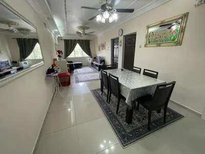 a dining room and living room with a table and chairs at Indah Putri Homestay in Kuala Lumpur