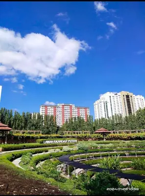 a park with tall buildings in the background with a pathway at Indah Putri Homestay in Kuala Lumpur