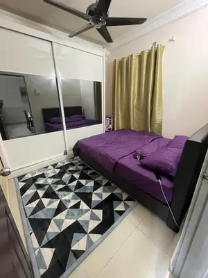 a bedroom with a purple bed and a mirror at Indah Putri Homestay in Kuala Lumpur