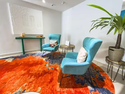 a room with two chairs and a rug at Living At DSulaiman Hotel in Kuala Lumpur