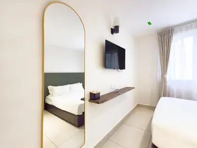 a mirror in a hotel room with a bed and a tv at Living At DSulaiman Hotel in Kuala Lumpur