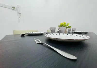 a black table with a fork and plates on it at Bintang Suites Kuala Lumpur City Centre in Kuala Lumpur