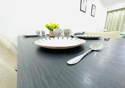 a dining room table with a plate and spoons on it at Bintang Suites Kuala Lumpur City Centre in Kuala Lumpur