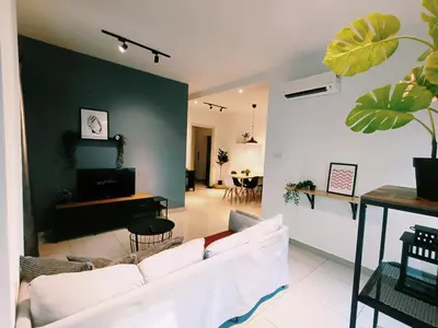 a living room with a white couch and a green wall at Arte Plus by Stay Relax in Kuala Lumpur