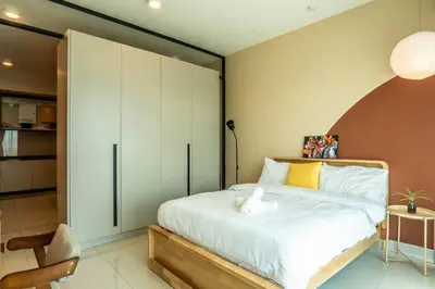 a bedroom with a large white bed and a chair at Datum Jelatek Residence by Airhost in Kuala Lumpur