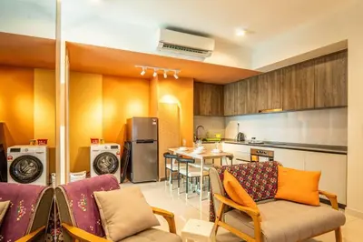a kitchen and living room with a couch and a table at Datum Jelatek Residence by Airhost in Kuala Lumpur