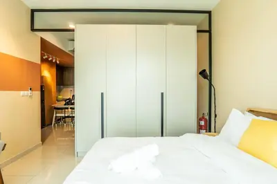 a bedroom with a white bed and a large closet at Datum Jelatek Residence by Airhost in Kuala Lumpur