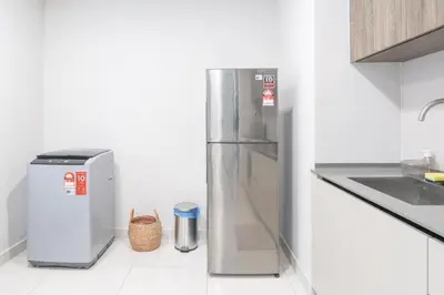a stainless steel refrigerator in a white kitchen at Datum Jelatek Residence by Airhost in Kuala Lumpur
