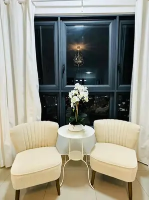 two chairs and a table with a vase of flowers at M Vertica KL City 3B2B 8 Pax [Wi-Fi, 2 Carparks] in Kuala Lumpur
