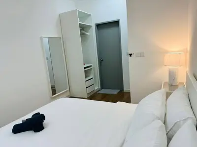 a black remote control sitting on a white bed at M Vertica KL City 3B2B 8 Pax [Wi-Fi, 2 Carparks] in Kuala Lumpur
