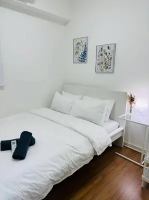 a white bed with a remote control on top of it at M Vertica KL City 3B2B 8 Pax [Wi-Fi, 2 Carparks] in Kuala Lumpur