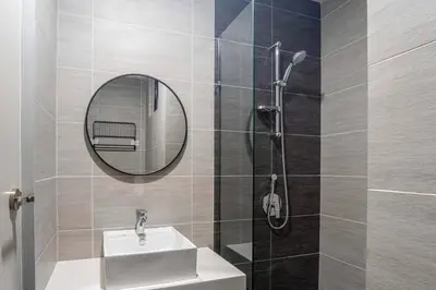 a bathroom with a sink and a shower with a mirror at Trion @ KL by Airhost in Kuala Lumpur