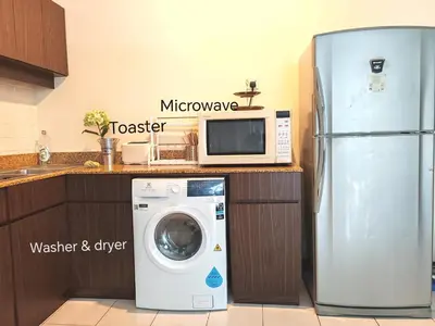 a microwave and a washing machine in a kitchen at 9 Bukit Bintang 5 minutes to Alor Street Seri Bukit Ceylon 2R2B 8 pax in Kuala Lumpur