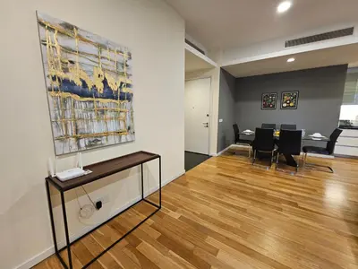 a living room with a table and a painting on the wall at Cosy Apartment at St Mary KL City Centre in Kuala Lumpur