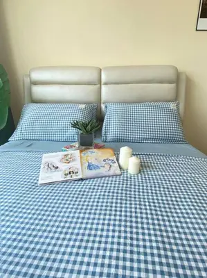 a bed with a blue and white checkered sheets and pillows at CozyVista Setapak Central Mall 10Pax 3BR 2CarPark in Kuala Lumpur