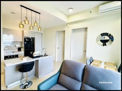 a living room with a couch and a kitchen at Skystays360 KL, 60th floor - close to KLCC TRX 2-bedroom 2 bathrooms in Kuala Lumpur