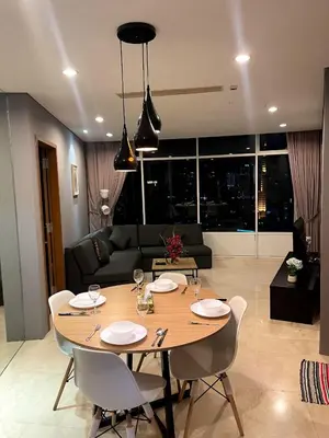 a dining table and chairs in a living room at Vortex Suites KLCC 10 Pax -3 Bedroom Apartment in Kuala Lumpur