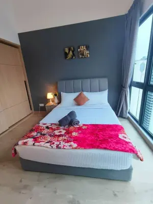 a bedroom with a large bed with a red blanket at The Luxe Suites Infinitum KLCC in Kuala Lumpur