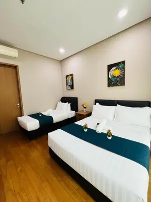 two beds in a hotel room with white and blue at Soho Star Suites near by Klcc in Kuala Lumpur