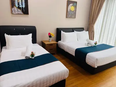 two beds in a hotel room with flowers on them at Soho Star Suites near by Klcc in Kuala Lumpur