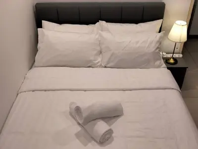 a white towel laying on top of a bed at MH Homestay 3R2B Condo very near to KLCC, Free Wi-Fi, Netflix & Parking in Kuala Lumpur