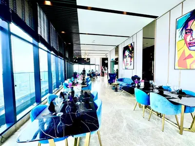 a restaurant with blue chairs and tables and windows at Star Residence Suite KLCC in Kuala Lumpur