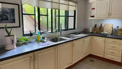 a kitchen with white cabinets and a sink and a window at Townhouse in KLCC Vicinity in Kuala Lumpur