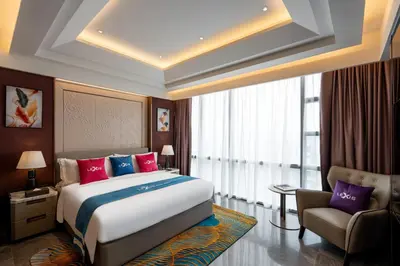 a bedroom with a large bed and a chair at Imperial Lexis Kuala Lumpur in Kuala Lumpur