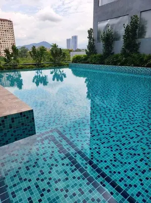 a swimming pool with blue tiles on the side of a building at Neu Suite Ampang, LRT Jelatek, Gleneagles Hospital in Kuala Lumpur