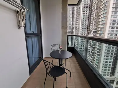 a table and two chairs on a balcony with tall buildings at Arcoris Mont Kiara 15# 163 Sunway Mall # 1 Mont Kiara in Kuala Lumpur