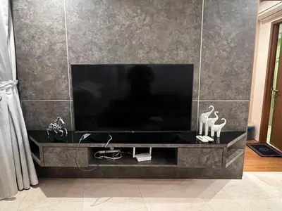 a flat screen tv sitting on a black entertainment center at Vortex KLCC (42) Amazing view in Kuala Lumpur