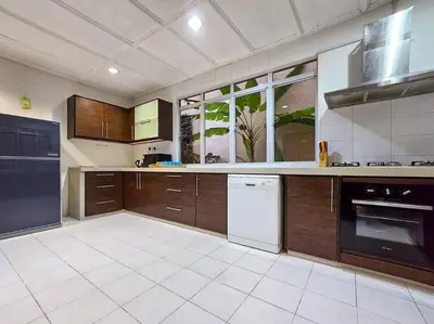 a large kitchen with wooden cabinets and white appliances at KL Secret Karaoke Private Pool Villa in Ampang