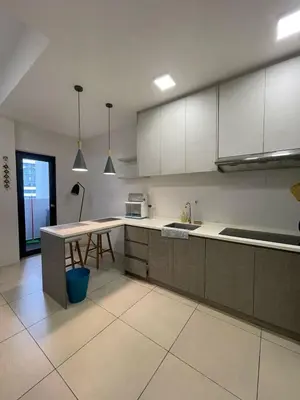 a kitchen with white cabinets and a table in it at Reizz Residence By Sweet Home in Kuala Lumpur