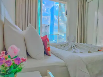 a bedroom with a bed with pillows and a window at Lila House One Bukit Ceylon in Kuala Lumpur