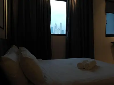a bedroom with a bed with two towels on it at Chambers A Studio Flat, KLCC & KL Tower view, City in Kuala Lumpur