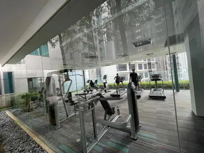a gym with people exercising on tread machines in a building at Mercu summer suites By Premium Charter in Kuala Lumpur